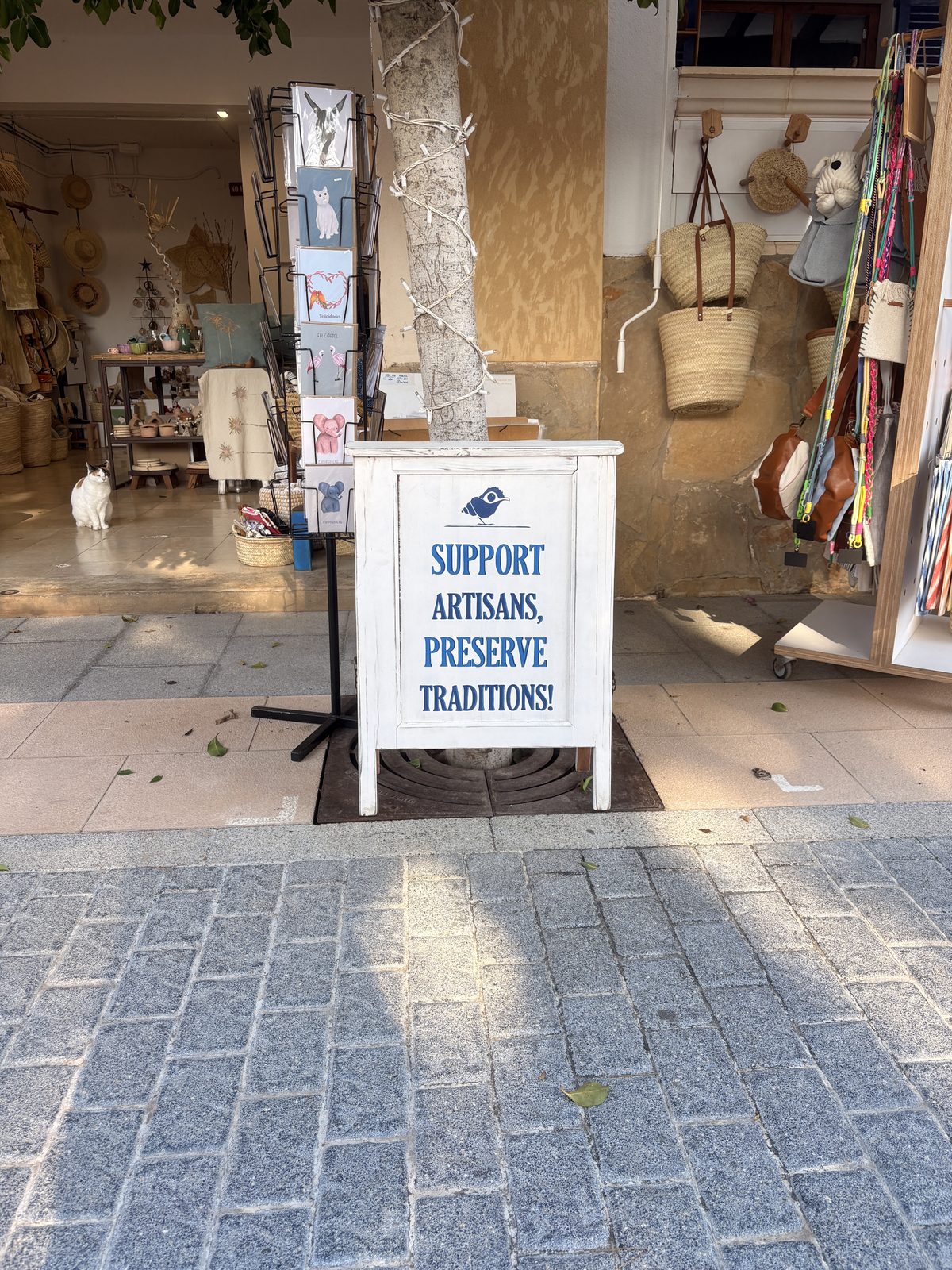 A shop sign in Mallorca reading 'Support Artisans, Preserve Traditions'